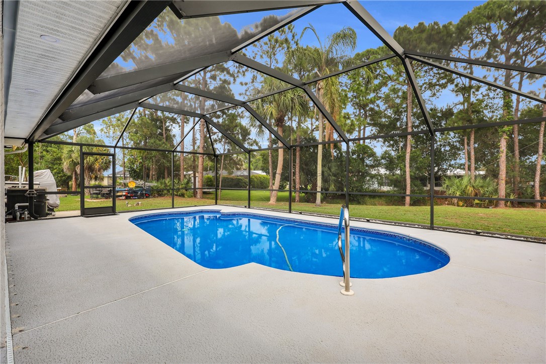 1950 Southwest Logwood Road Port St. Lucie, FL 34953 - Photo 26 of 32 a swimming pool with outdoor seating and yard
