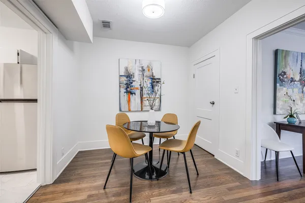 a kitchen with stainless steel appliances white cabinets and a stove a refrigerator with wooden floors