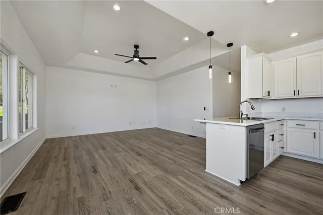 a kitchen with stainless steel appliances granite countertop a sink a stove and a wooden floors