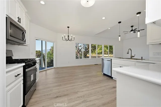 a kitchen with stainless steel appliances granite countertop a sink cabinets and wooden floor