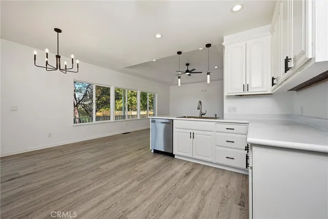 a kitchen with stainless steel appliances granite countertop a sink cabinets and wooden floor
