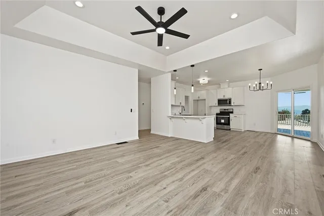 a room with kitchen island stainless steel appliances sink cabinets and wooden floor