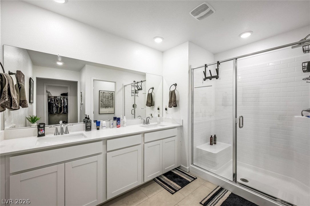 175 Hazel Heights Henderson, NV 89011 - Photo 20 of 55 Bathroom with double vanity, a stall shower, a walk in closet, light tile patterned floors, and recessed lighting