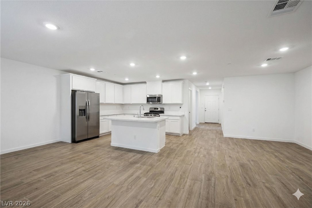 175 Hazel Heights Henderson, NV 89011 - Photo 55 of 55 Kitchen with stainless steel appliances, white cabinets, open floor plan, light wood-style floors, and recessed lighting