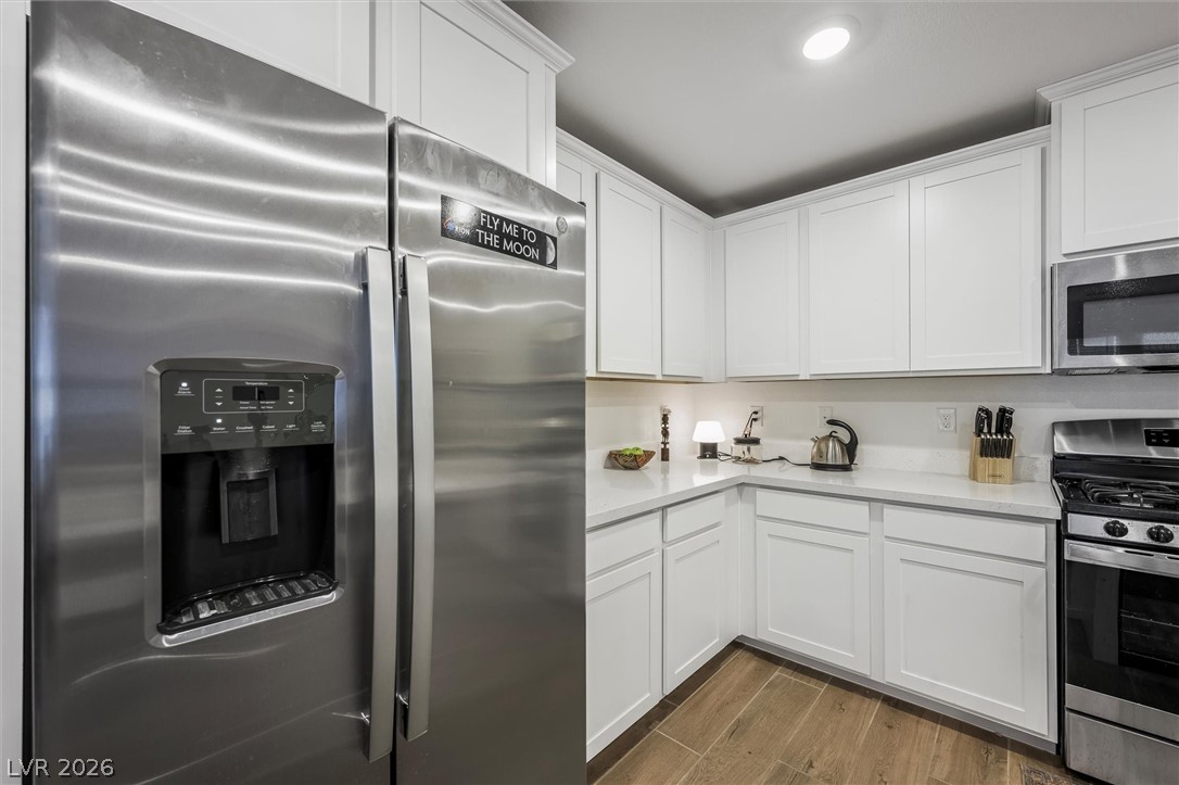 175 Hazel Heights Henderson, NV 89011 - Photo 9 of 55 Kitchen with stainless steel appliances, white cabinets, and dark wood-style floors