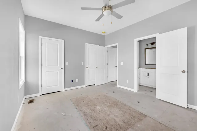 an empty room with closet and a chandelier fan
