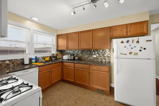 a kitchen with stainless steel appliances granite countertop a refrigerator sink and cabinets