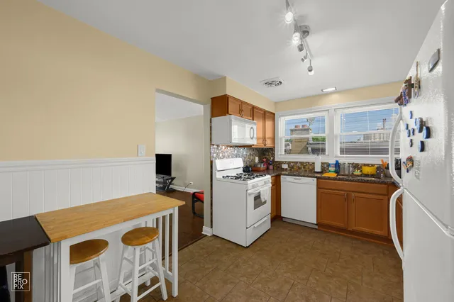 a kitchen with stainless steel appliances granite countertop a stove top oven a sink dishwasher and a refrigerator