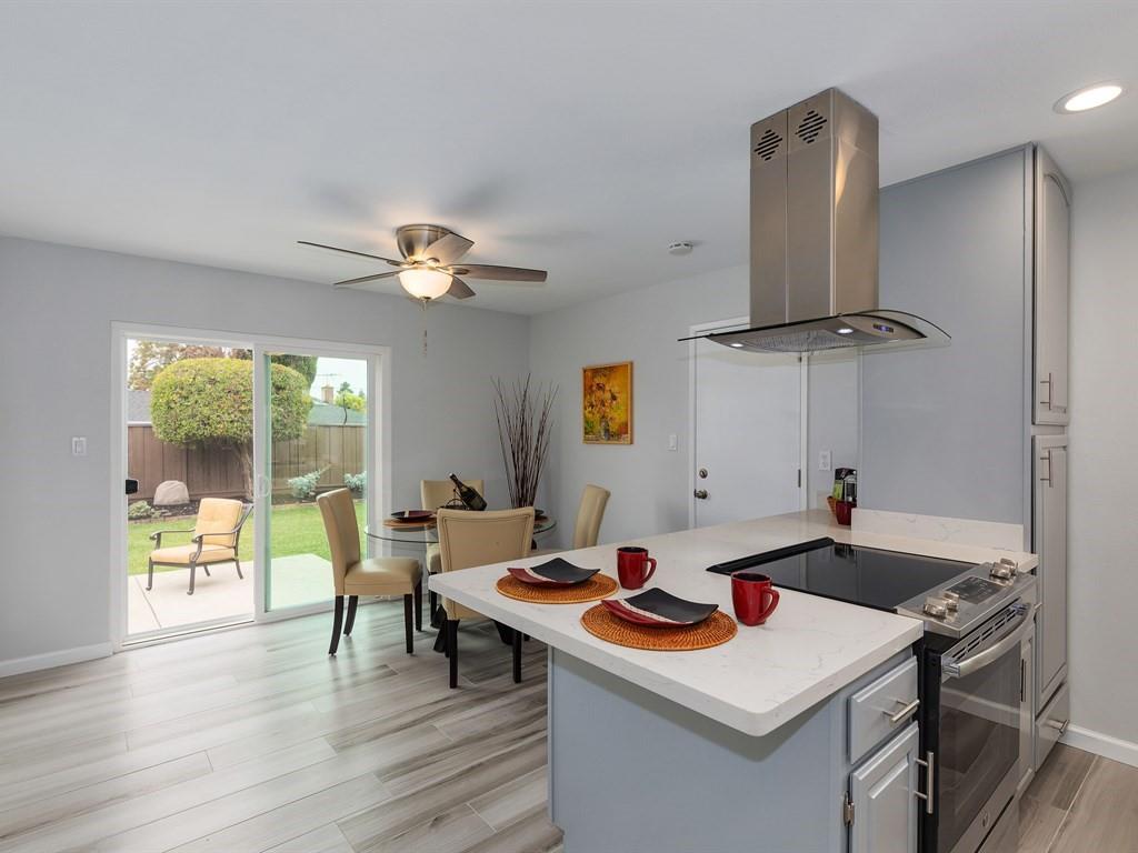 6258 Castillon Drive Newark, CA 94560 - Photo 3 of 20 a kitchen with a stove a counter space and a dining table with garden view