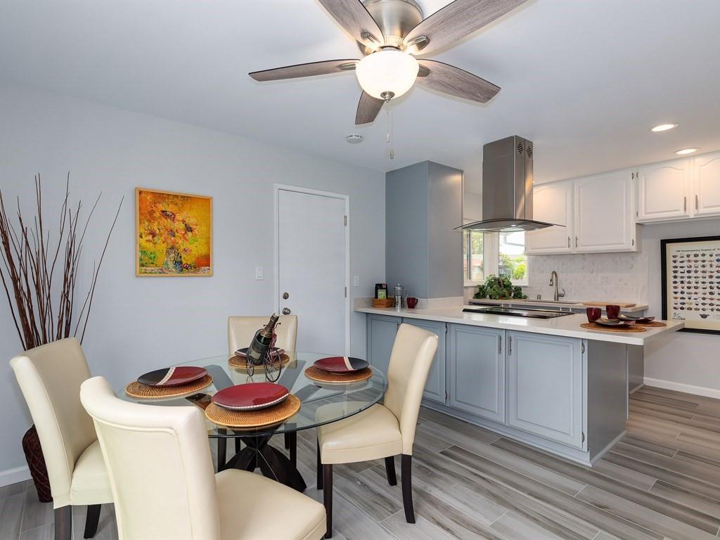 6258 Castillon Drive Newark, CA 94560 - Photo 8 of 20 a kitchen with a stove a sink a dining table and chairs with wooden floor