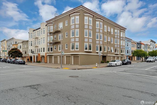 a city street lined with parked cars and buildings