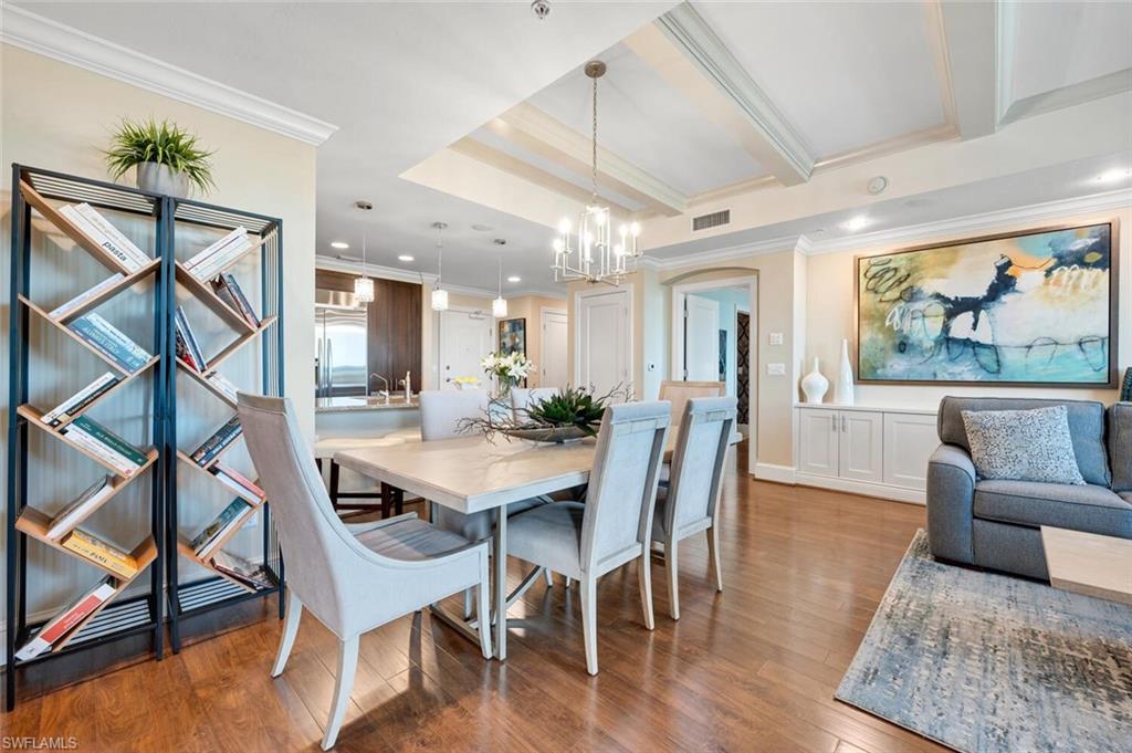 9115 Strada Place, Unit 5505 Naples, FL 34108 - Photo 5 of 44 Dining area with wood-style flooring, ornamental molding, and a notable chandelier