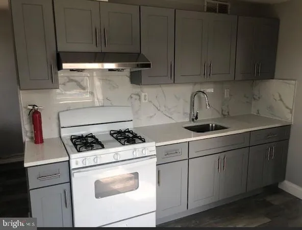 a kitchen with stainless steel appliances granite countertop a sink stove and cabinets