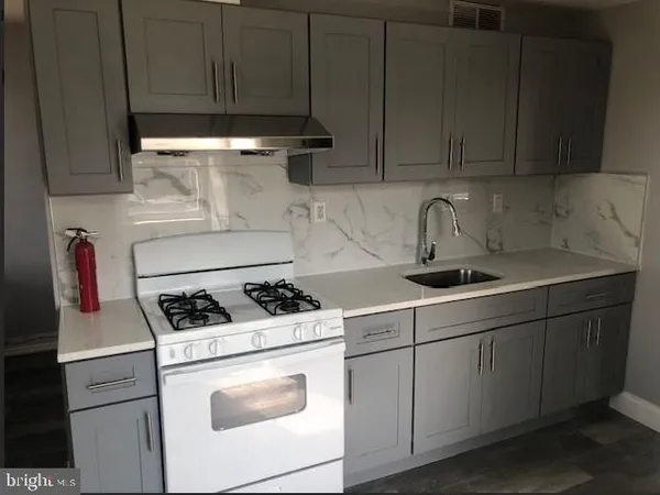 a kitchen with stainless steel appliances granite countertop a sink stove and cabinets
