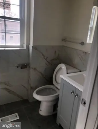 a white toilet sitting next to a window
