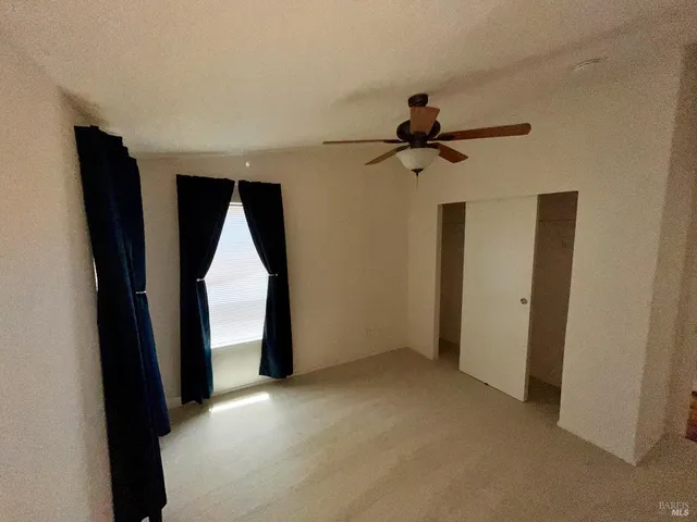 a view of empty room with ceiling fan