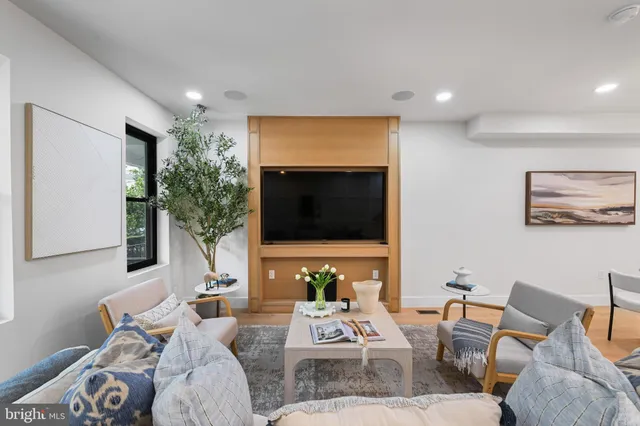 a living room with furniture a flat screen tv and a large window