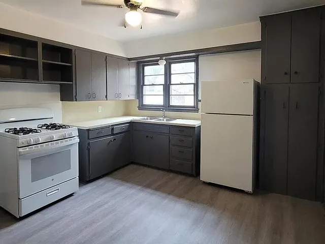 a kitchen with a white stove a sink and dishwasher
