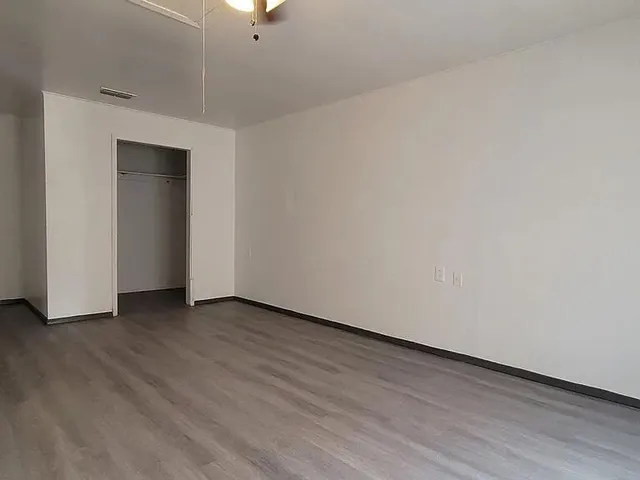 a view of an empty room with wooden floor