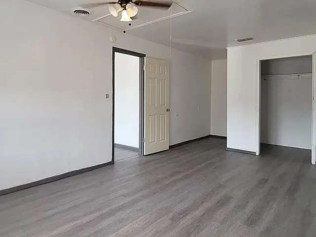 a view of a room with wooden floor and chandelier