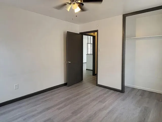 a view of an empty room with wooden floor