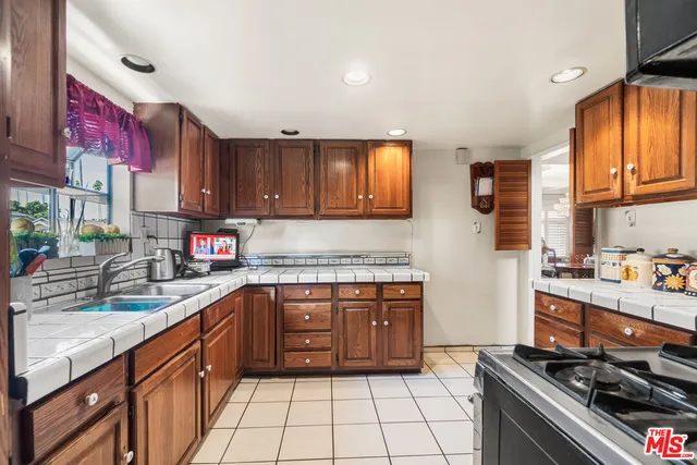 a kitchen with stainless steel appliances granite countertop a sink stove and cabinets