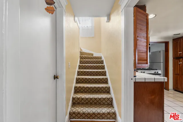 a bedroom with a bed flat screen tv and a chandelier