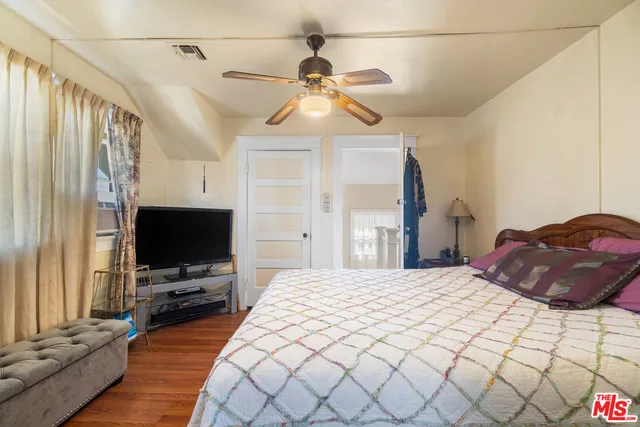 a bedroom with a bed and a flat screen tv