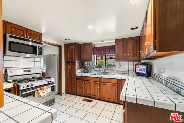 a kitchen with stainless steel appliances a stove a sink and a refrigerator