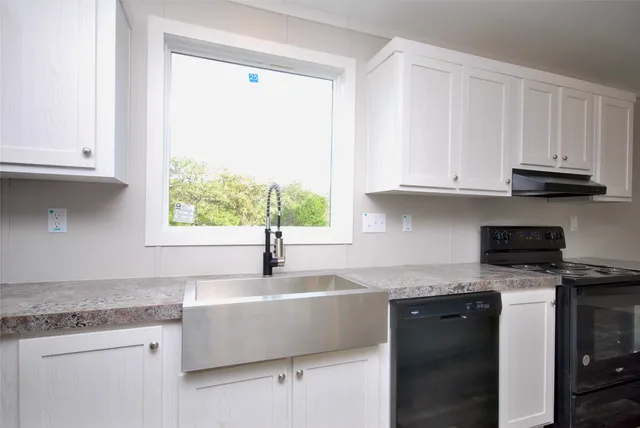 a kitchen with granite countertop a sink and a window
