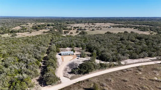 an aerial view of a house with a yard and lake view