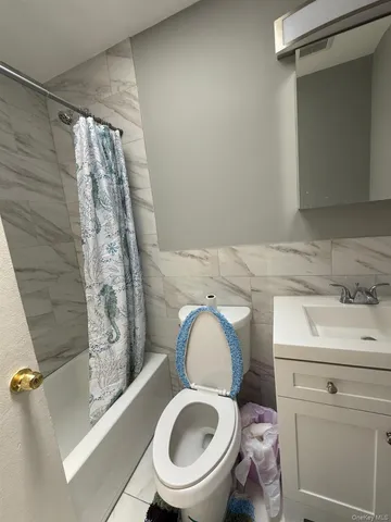 a bathroom with a granite countertop toilet sink and mirror