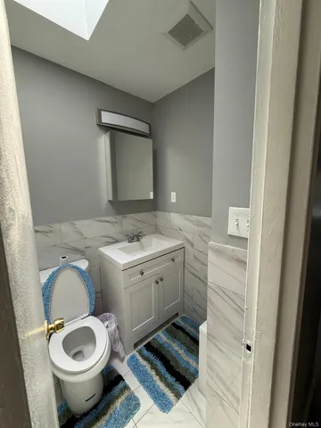 a bathroom with a granite countertop toilet sink and mirror