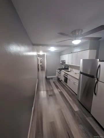 a view of a refrigerator in kitchen and wooden floor