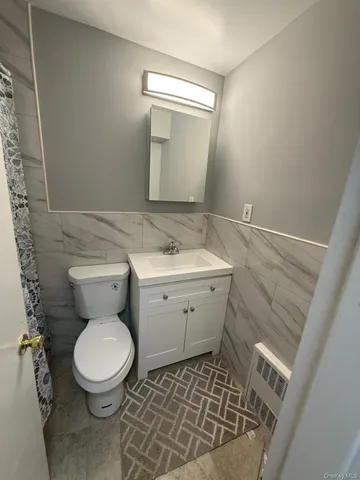 a bathroom with a toilet a sink and a mirror