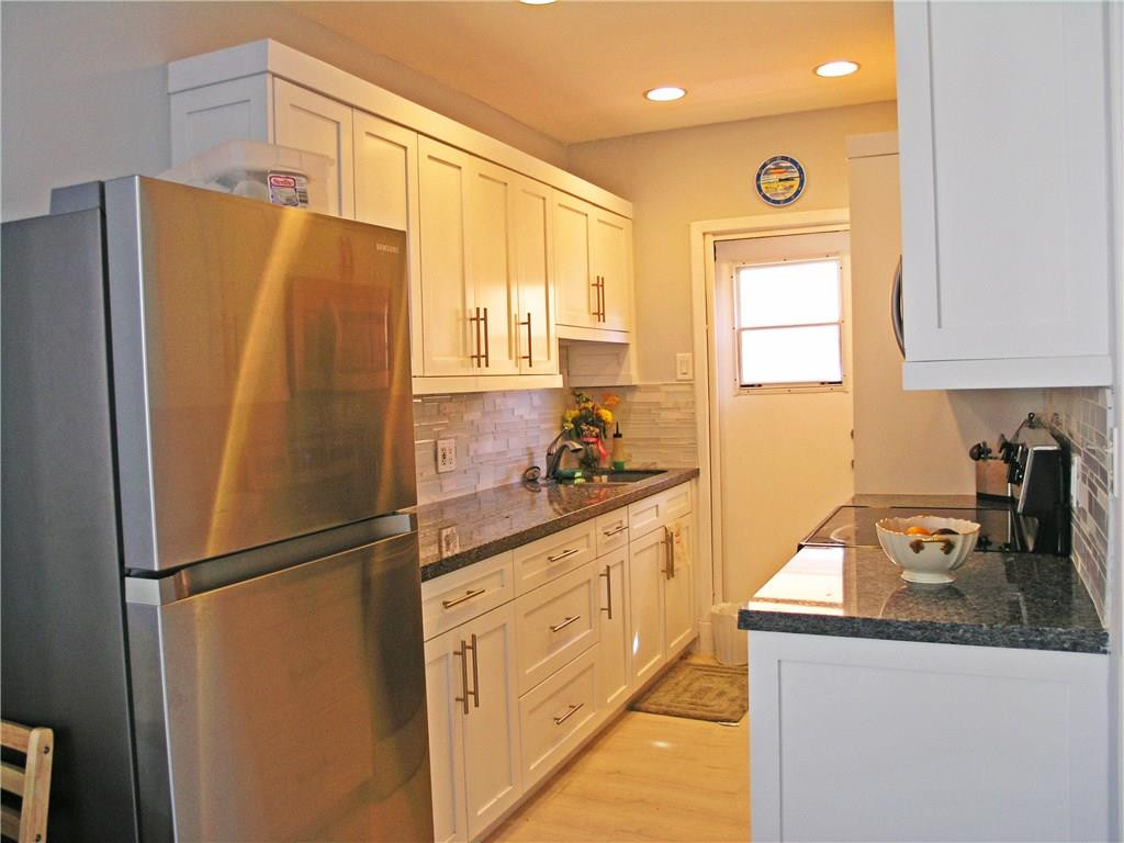 1910 North Surf Road, Unit 7 Hollywood, FL 33019 - Photo 3 of 17 a kitchen with granite countertop a refrigerator and a sink