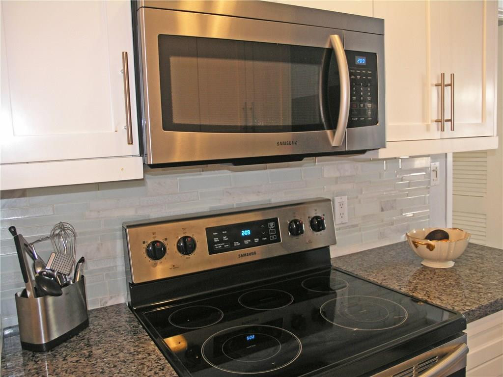 1910 North Surf Road, Unit 7 Hollywood, FL 33019 - Photo 4 of 17 a kitchen with a stove and a microwave