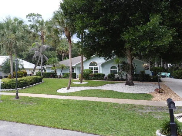 a front view of a house with a yard and tree s