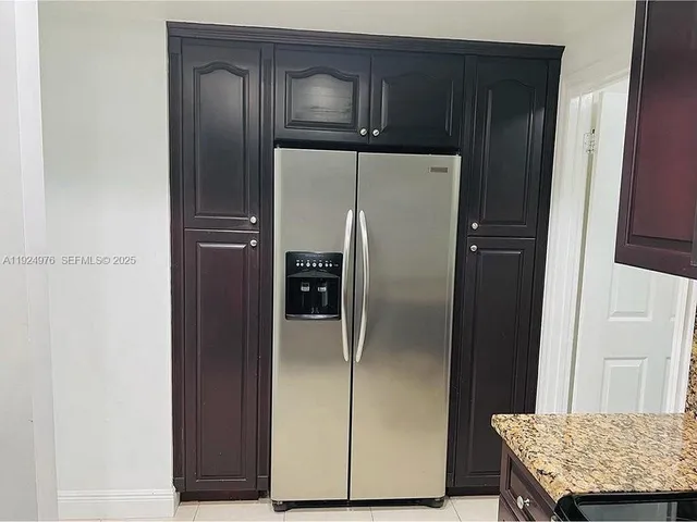 a kitchen with a refrigerator and cabinets