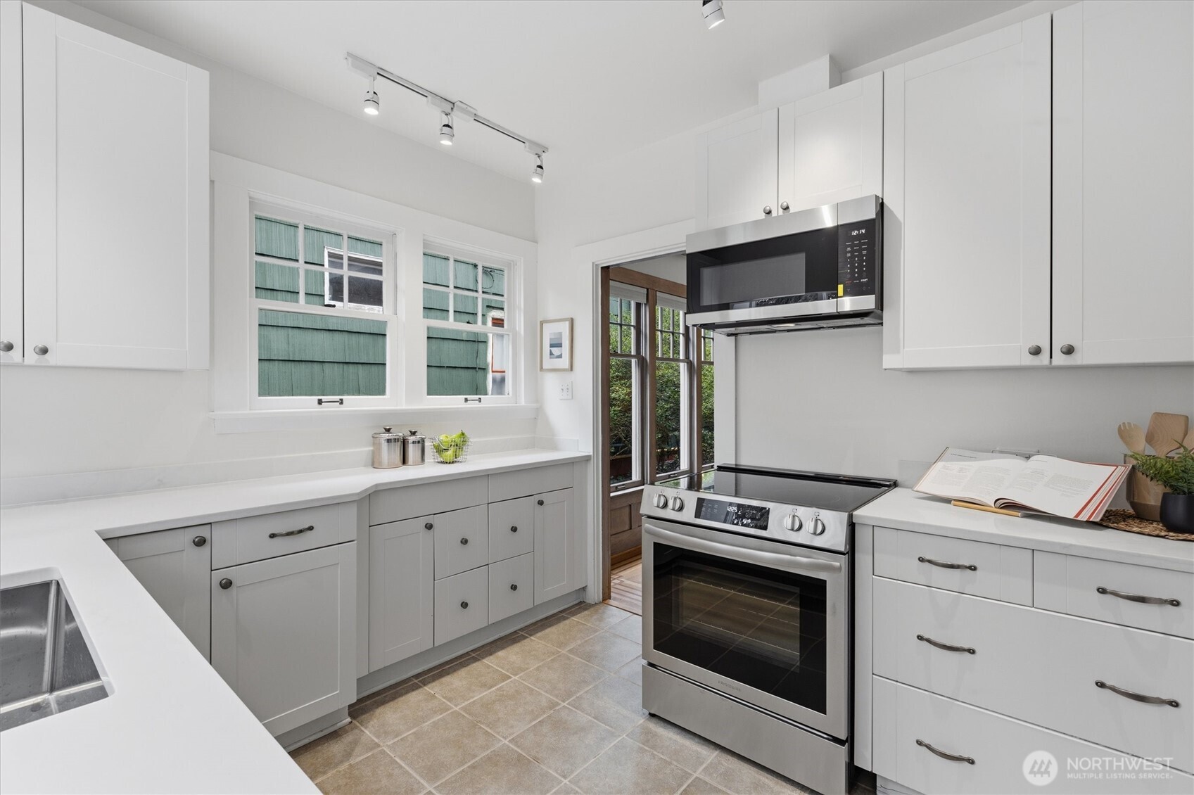 715 North 48th Street Seattle, WA 98103 - Photo 14 of 37 a kitchen with granite countertop white cabinets stainless steel appliances and sink