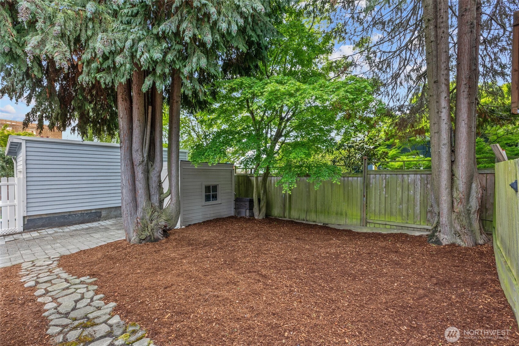 715 North 48th Street Seattle, WA 98103 - Photo 20 of 37 a view of a house with large trees and a small yard