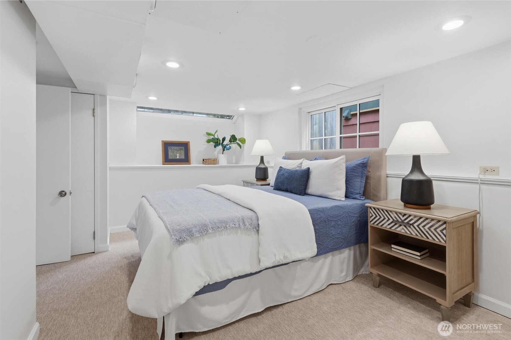 715 North 48th Street Seattle, WA 98103 - Photo 23 of 37 a spacious bedroom with a bed and a lamp on table