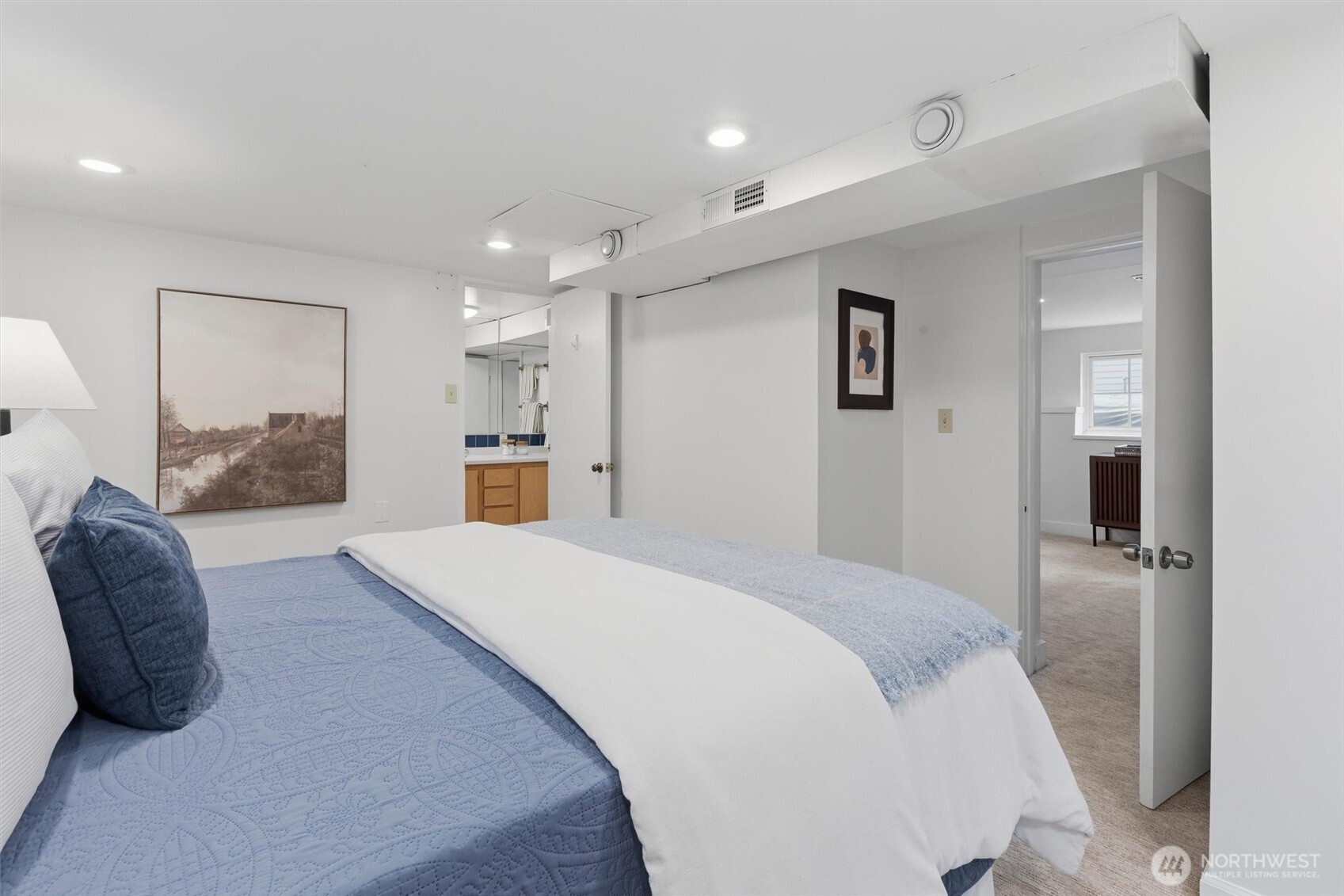 715 North 48th Street Seattle, WA 98103 - Photo 24 of 37 a spacious bedroom with a bed and a large mirror