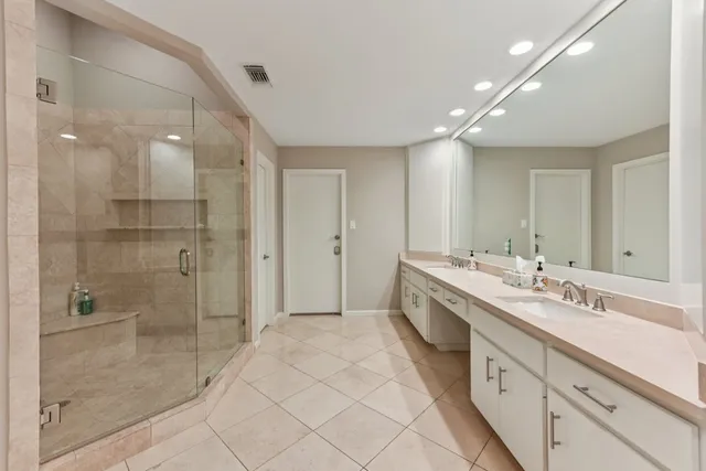 a spacious bathroom with a double vanity sink mirror and shower