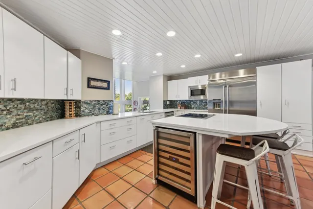 a kitchen with a stove a refrigerator and white cabinets