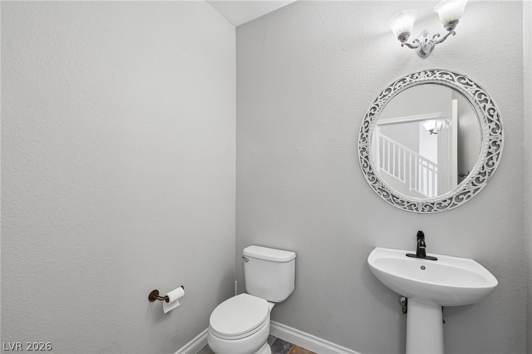 1727 Millstream Way Henderson, NV 89074 - Photo 22 of 46 A well-appointed half-bath with a stylish mirror and elegant wall sconces for guest convenience.