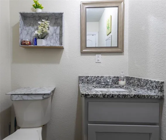 a bathroom with a toilet sink and mirror