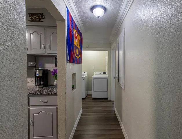 a view of a hallway with wooden floor and cabinets