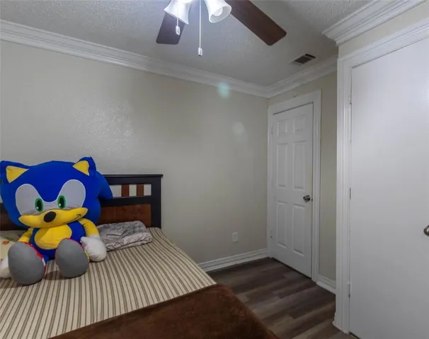 a bedroom with a bed and teddy bear on dresser