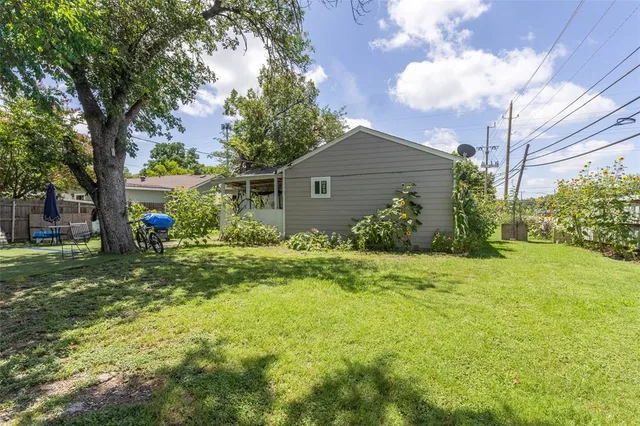 a backyard of a house with plants and tree